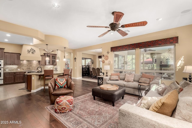 living room with dark wood-type flooring, sink, and ceiling fan