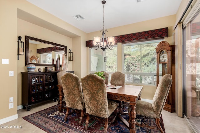 tiled dining room with a chandelier