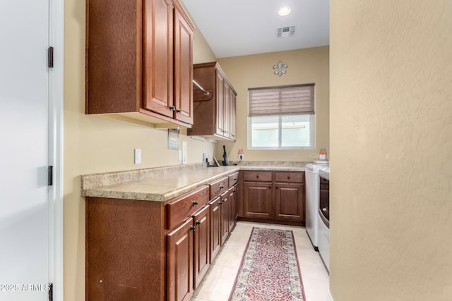 kitchen featuring light tile patterned floors and washing machine and clothes dryer