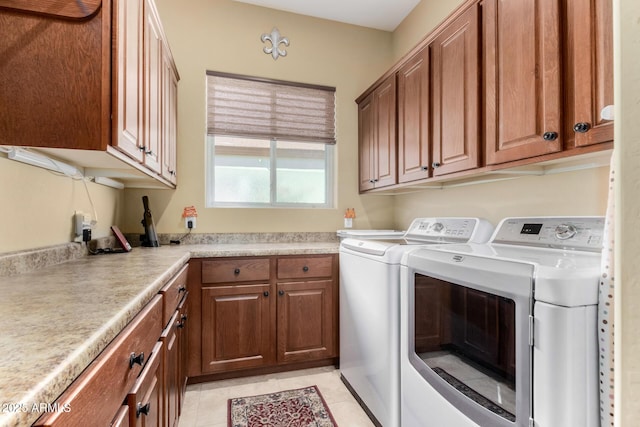 laundry area with cabinets, washer and dryer, and light tile patterned floors