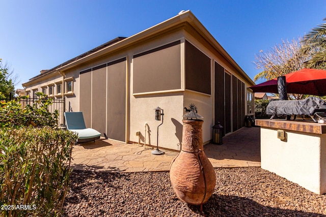 view of home's exterior featuring a sunroom and a patio