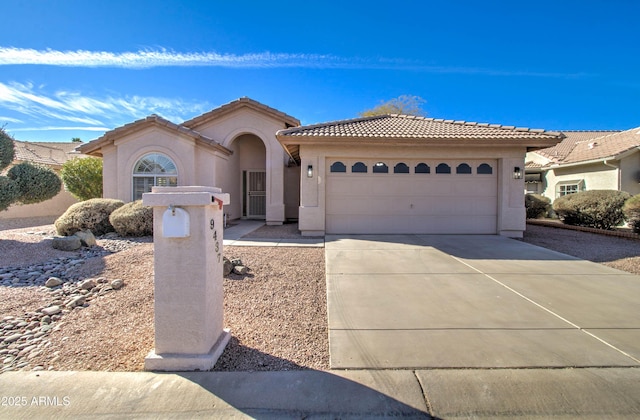 mediterranean / spanish-style house featuring a garage, driveway, a tile roof, and stucco siding