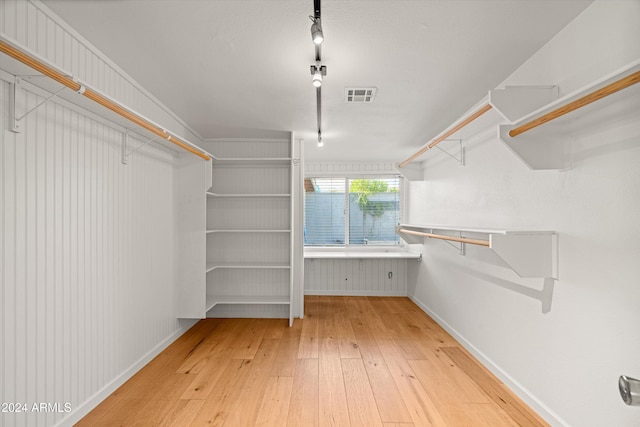 walk in closet with hardwood / wood-style flooring