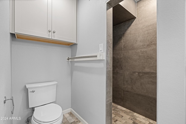 bathroom with tiled shower and toilet