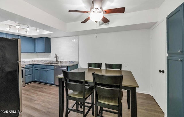 1075 E Chandler Blvd Unit 210, Chandler, AZ 85225 - kitchen featuring appliances with stainless steel finishes, ceiling fan, blue cabinetry, and wood finished floors