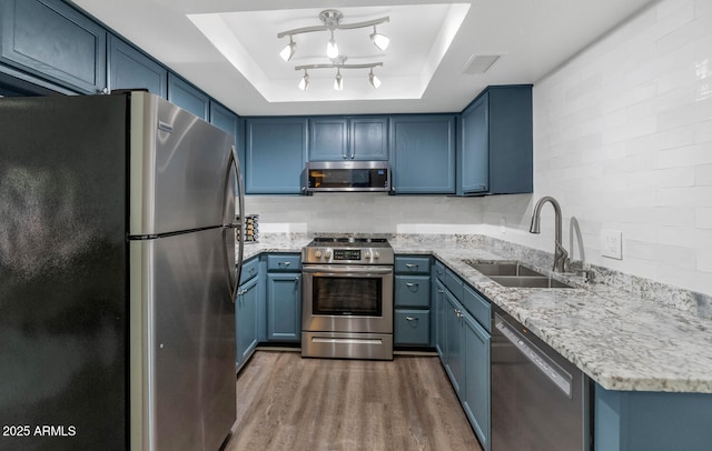 1075 E Chandler Blvd Unit 210, Chandler, AZ 85225 - kitchen with stainless steel appliances, blue cabinetry, wood finished floors, and light stone counters