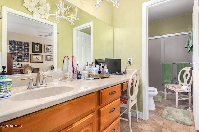 bathroom featuring an inviting chandelier, walk in shower, toilet, vanity, and tile patterned floors