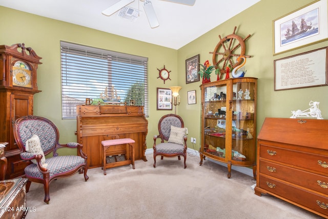 sitting room featuring light colored carpet and ceiling fan