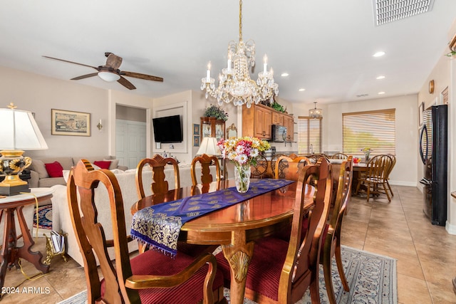 dining room with light tile patterned floors and ceiling fan with notable chandelier