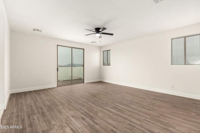 unfurnished room featuring dark wood-type flooring and ceiling fan