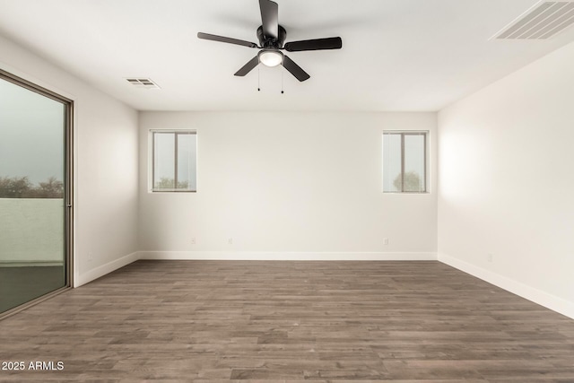 spare room with dark wood-type flooring and ceiling fan