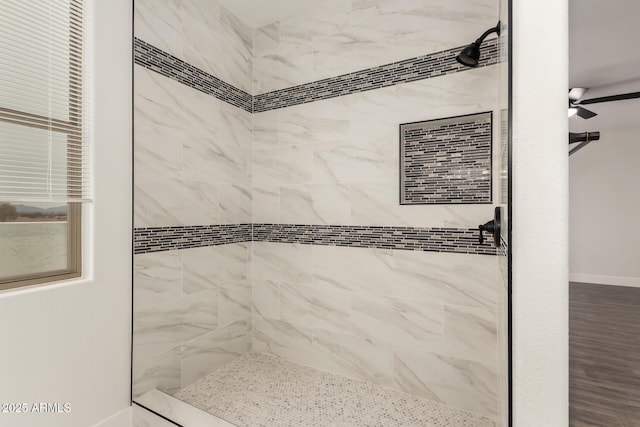bathroom featuring tiled shower and ceiling fan