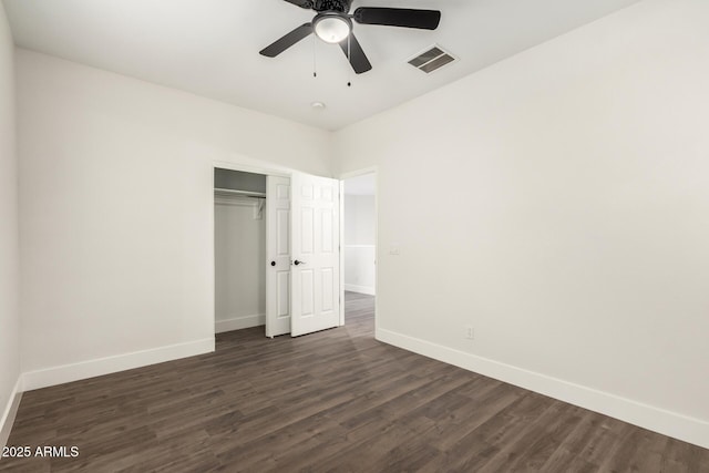 unfurnished bedroom with dark hardwood / wood-style flooring, a closet, and ceiling fan