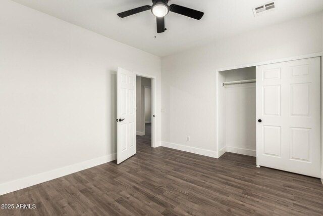 unfurnished bedroom with dark hardwood / wood-style floors, ceiling fan, and a closet