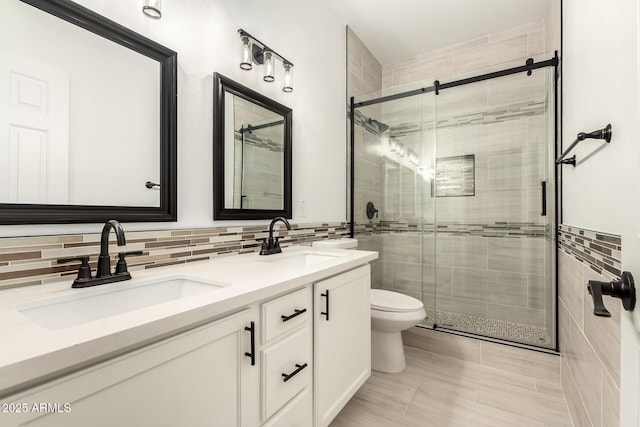 bathroom featuring vanity, toilet, tile walls, and walk in shower