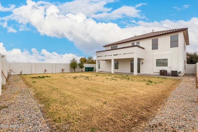 back of house featuring a lawn, a balcony, central air condition unit, and a patio area
