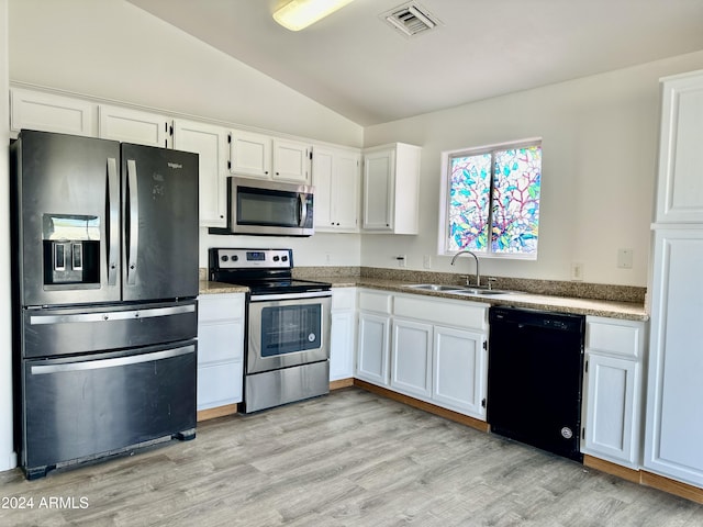 kitchen featuring lofted ceiling, sink, light hardwood / wood-style flooring, white cabinetry, and stainless steel appliances