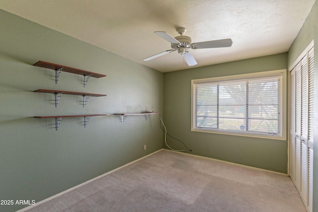 unfurnished room featuring baseboards, ceiling fan, and light carpet
