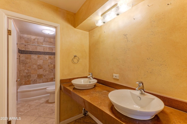 full bath featuring a sink, tile patterned floors, toilet, and  shower combination