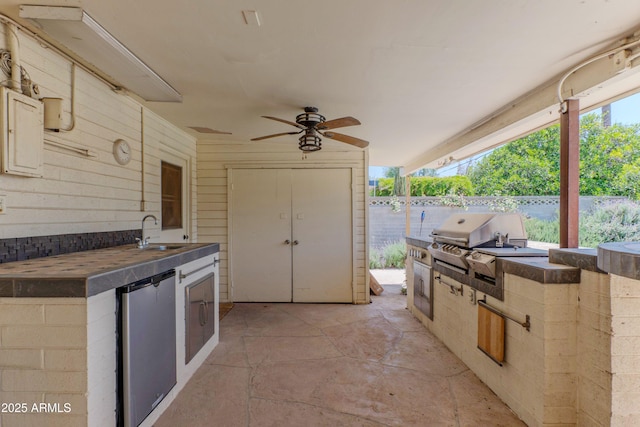 view of patio / terrace with area for grilling, ceiling fan, fence, and a sink