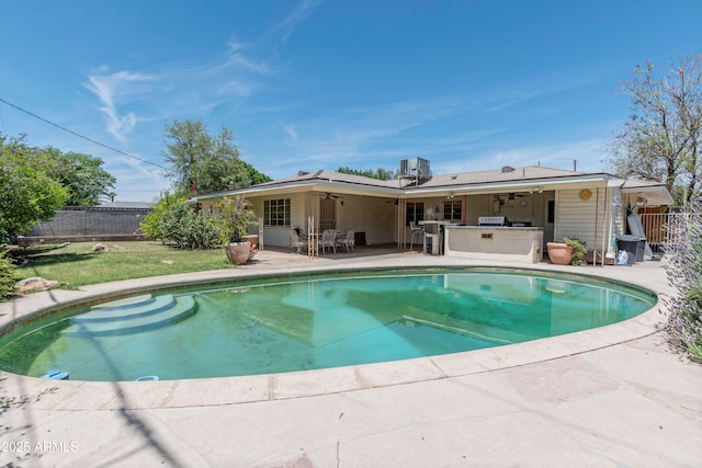view of pool with ceiling fan, a patio, a fenced backyard, outdoor dry bar, and a fenced in pool