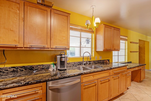 kitchen featuring stainless steel dishwasher, a sink, dark stone countertops, an inviting chandelier, and light tile patterned flooring
