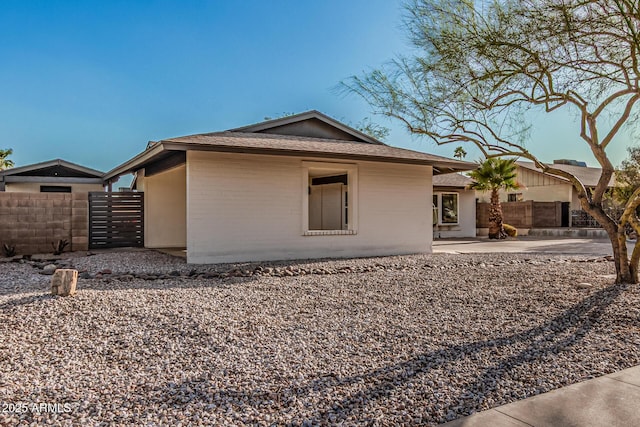 rear view of property with brick siding, fence, and a patio