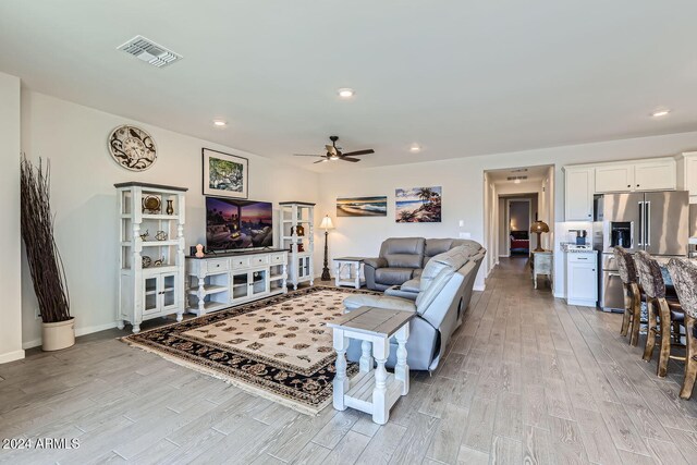 living room with light wood-type flooring and ceiling fan