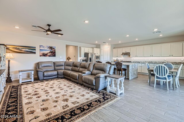 living room featuring light hardwood / wood-style floors and ceiling fan