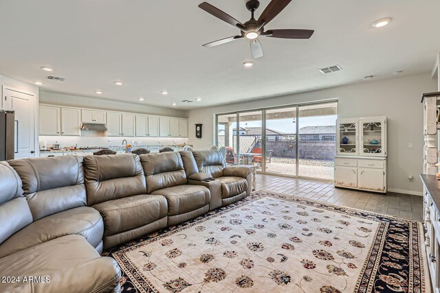 living room with light hardwood / wood-style flooring and ceiling fan