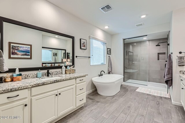 bathroom with vanity, hardwood / wood-style floors, and independent shower and bath