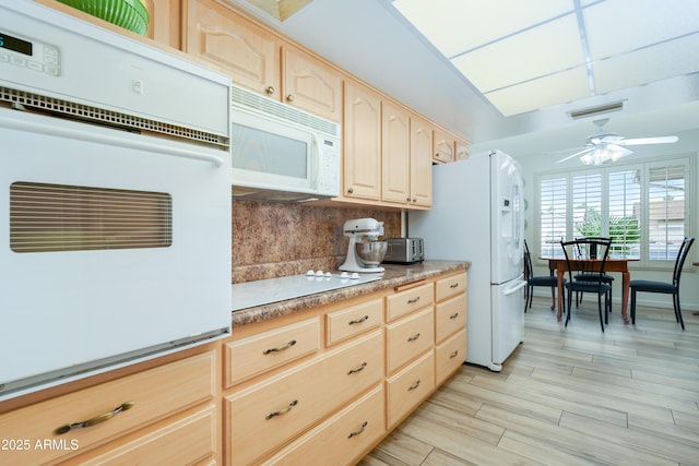 15430 N Bowling Green Dr, Sun City, AZ 85351 - kitchen with white appliances, light brown cabinetry, light countertops, and decorative backsplash