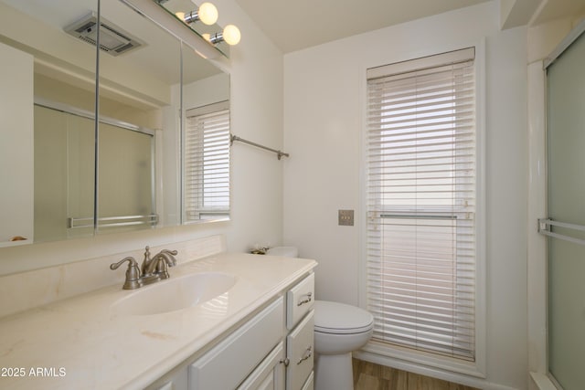 15430 N Bowling Green Dr, Sun City, AZ 85351 - bathroom with toilet, wood finished floors, a shower with door, visible vents, and vanity