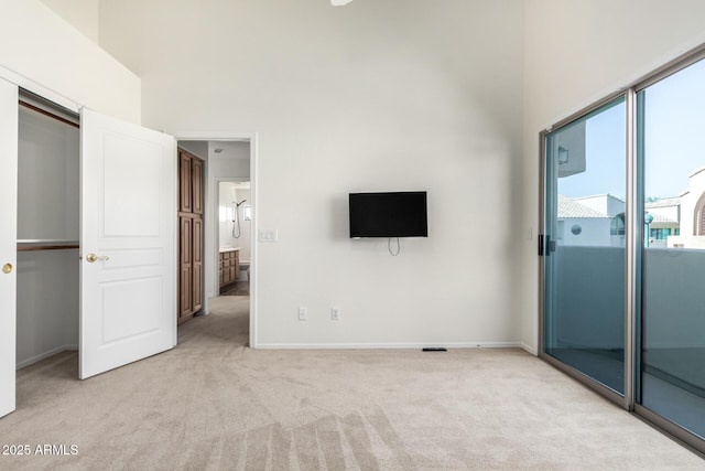 6510 S Hazelton Ln Unit 101, Tempe, AZ 85283 - unfurnished bedroom featuring light carpet, a towering ceiling, and a closet