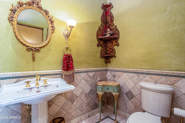 bathroom featuring tile walls and toilet