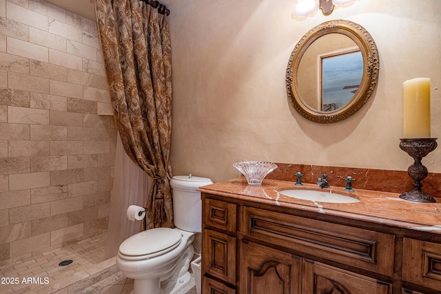 bathroom with vanity, toilet, and a tile shower