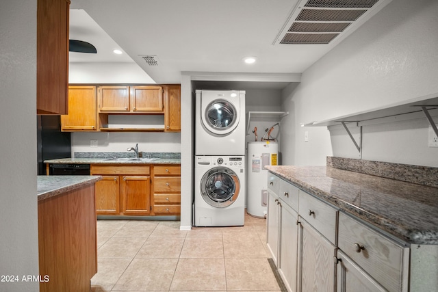 washroom featuring light tile patterned floors, electric water heater, stacked washer and clothes dryer, and sink