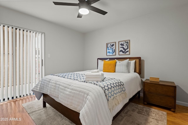 bedroom with wood finished floors, ceiling fan, and baseboards