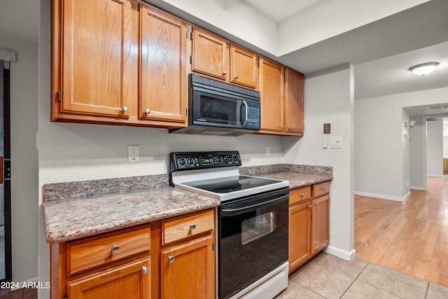 kitchen with light stone counters, light tile patterned flooring, and white electric stove