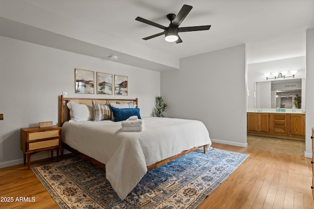 bedroom featuring baseboards, light wood-type flooring, ensuite bath, and ceiling fan