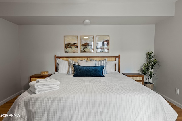 bedroom featuring wood finished floors and baseboards