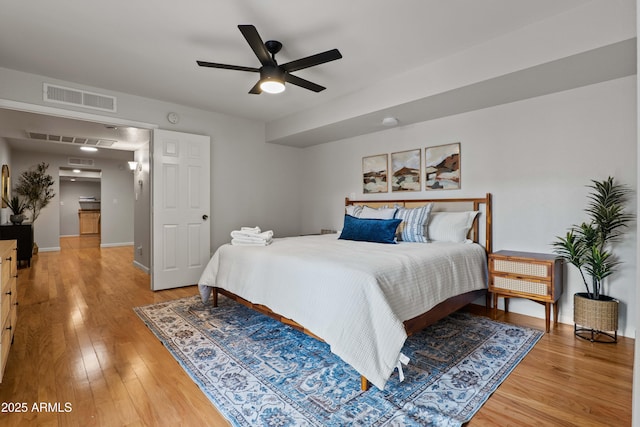 bedroom with light wood-style flooring, baseboards, and a ceiling fan