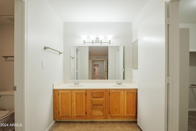 bathroom with tile patterned flooring, vanity, and toilet