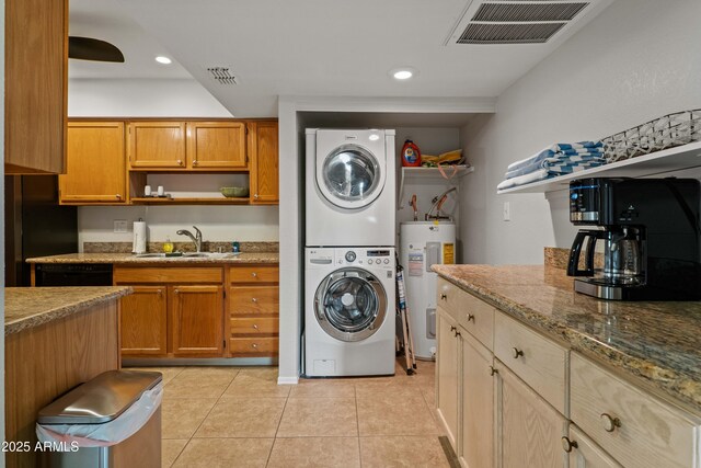 laundry room featuring estacked washer and dryer, electric water heater, and light tile patterned flooring