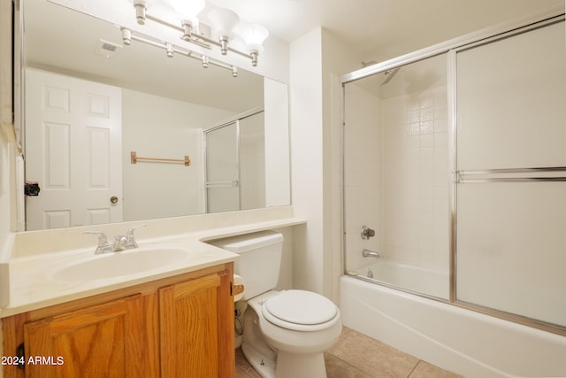 full bathroom featuring tile patterned floors, vanity, toilet, and bath / shower combo with glass door