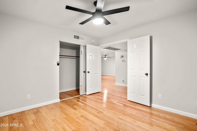 unfurnished bedroom featuring light wood-type flooring, a closet, and ceiling fan