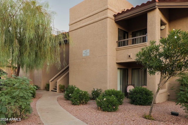 view of side of property with stucco siding and a tile roof