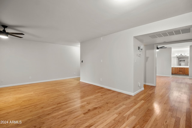 empty room with ceiling fan and light hardwood / wood-style flooring