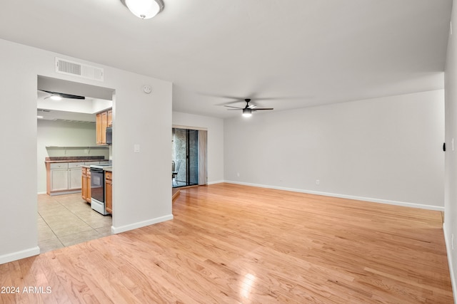 unfurnished living room with ceiling fan and light wood-type flooring