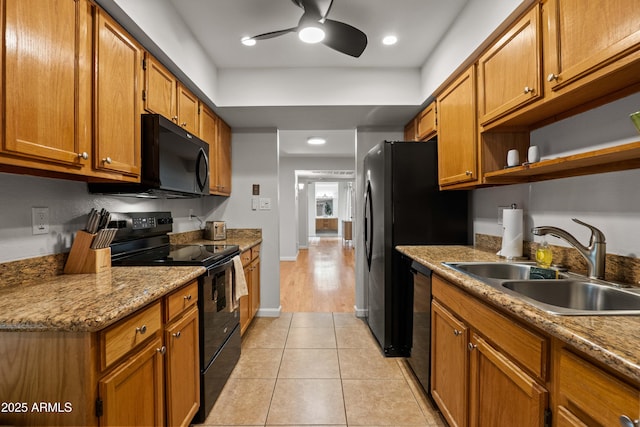 kitchen featuring black appliances, a sink, a ceiling fan, and brown cabinetry
